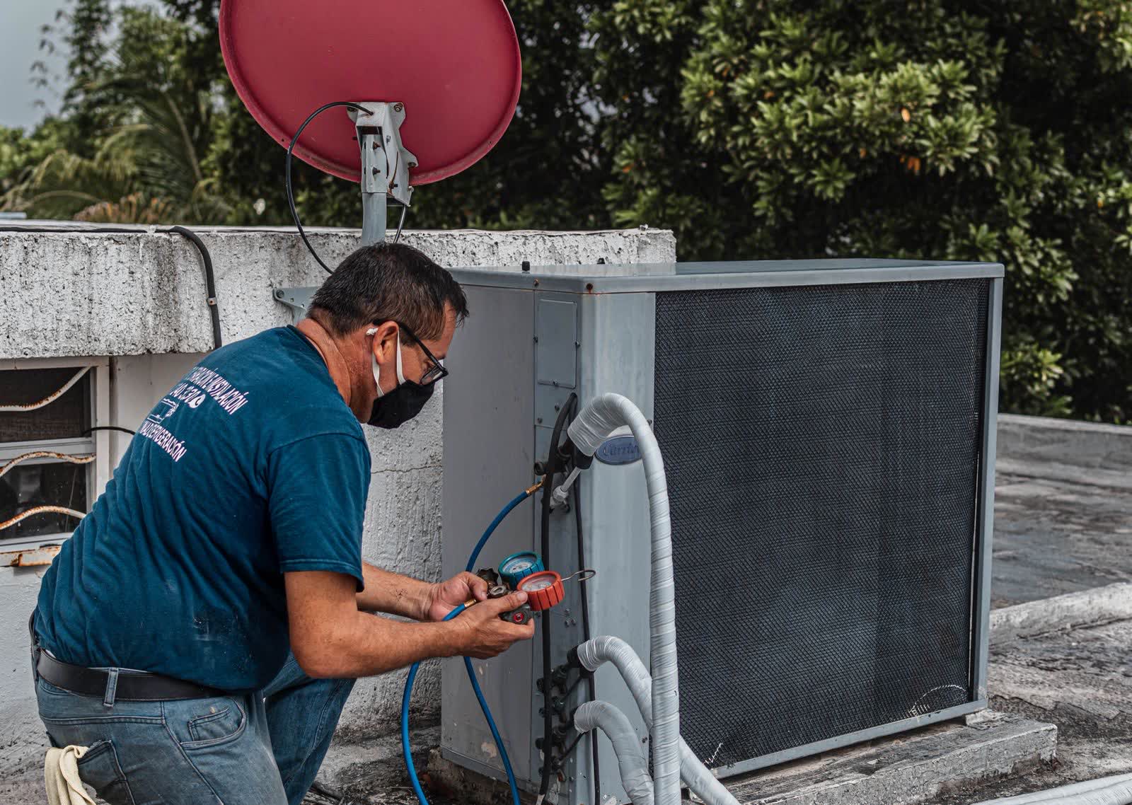 Technician repairing a rooftop air conditioning unit