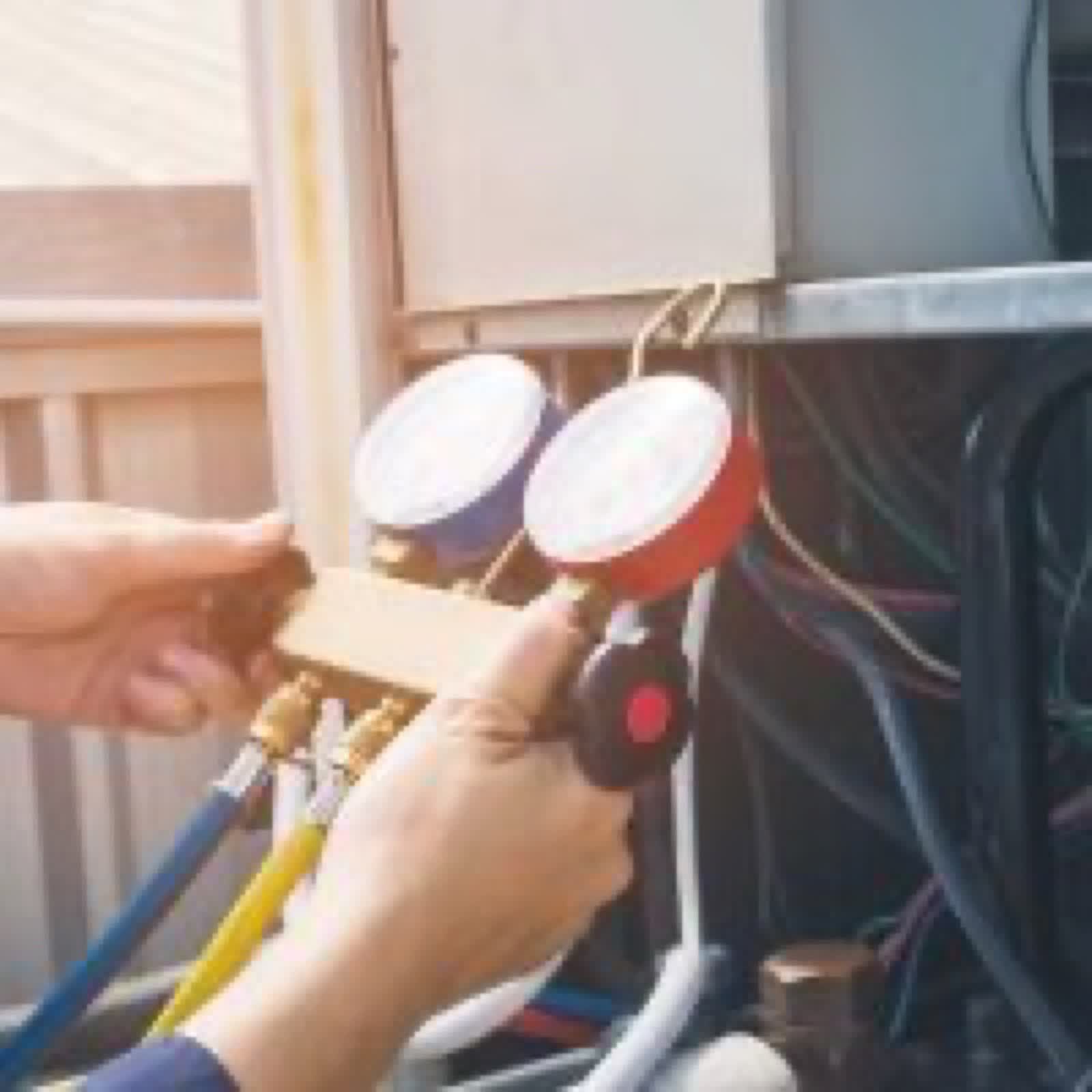 Technician checking refrigerant gauges