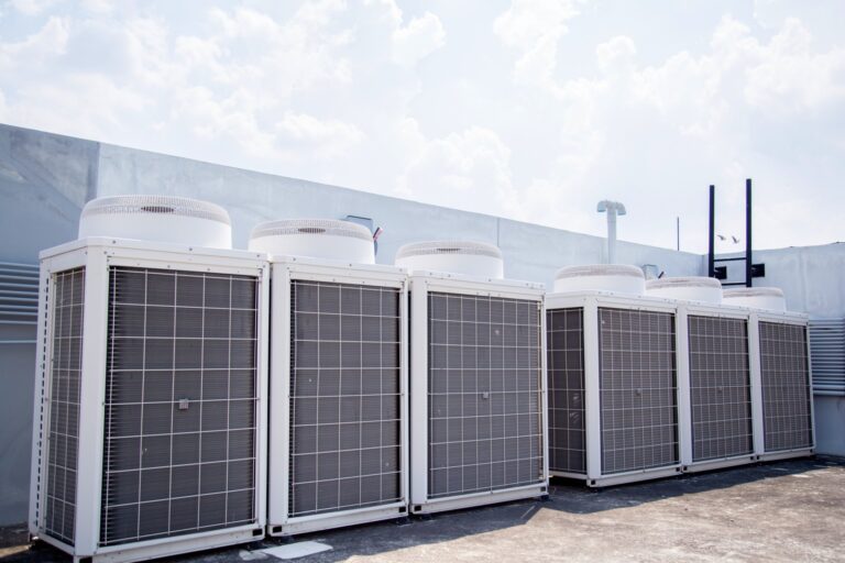 A row of air conditioners on top of a building.