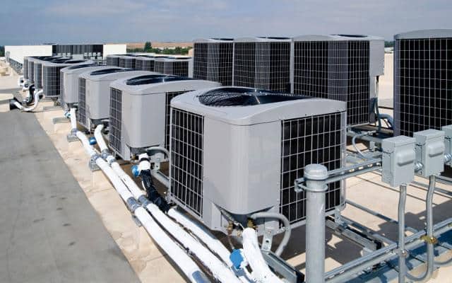 A group of air conditioners sitting on top of a building.
